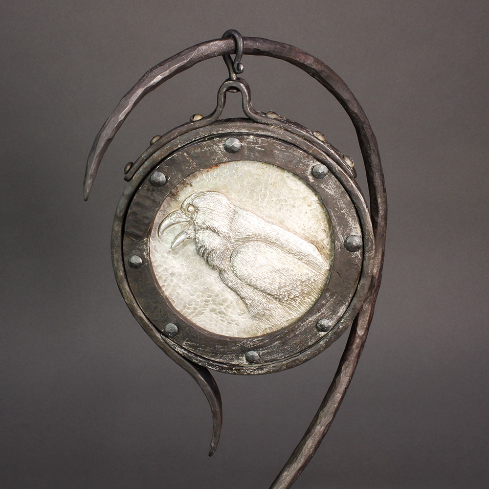 Standing iron mirror with chased aluminum raven